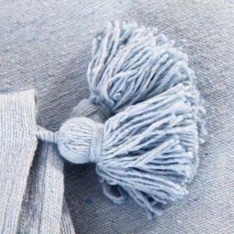 Jasnoniebieski pled bawełniany. Ręcznie tkana narzuta w kolorze pastelowego błękitu z chwostami. Idealny dodatek do pokoju dziecięcego i salonu.