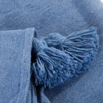 Niebieska narzuta bawełniana w kolorze dżinsowym. Ręcznie tkany, kwadratowy pled z ozdobnymi chwostami. Stylowy dodatek do wnętrz Hampton i nowoczesnych.