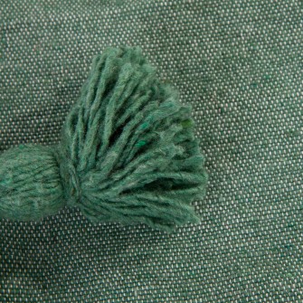 Zielony pled bawełniany. Ręcznie tkana narzuta w kolorze szałwiowym z chwostami. Idealny bieżnik na łóżko i do fotela.