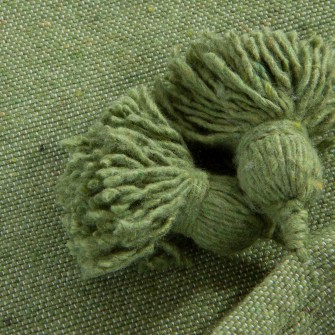 Zielony pled bawełniany. Ręcznie tkana narzuta w kolorze groszkowym z chwostami. Energetyczny i świeży dodatek do wnętrz.