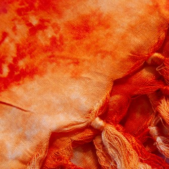 Chusta z rayonu 160×112 cm (+/3) w pomarańczowożółtym tiedye z frędzlami. Lekka, efektowna, na ramiona i szyję